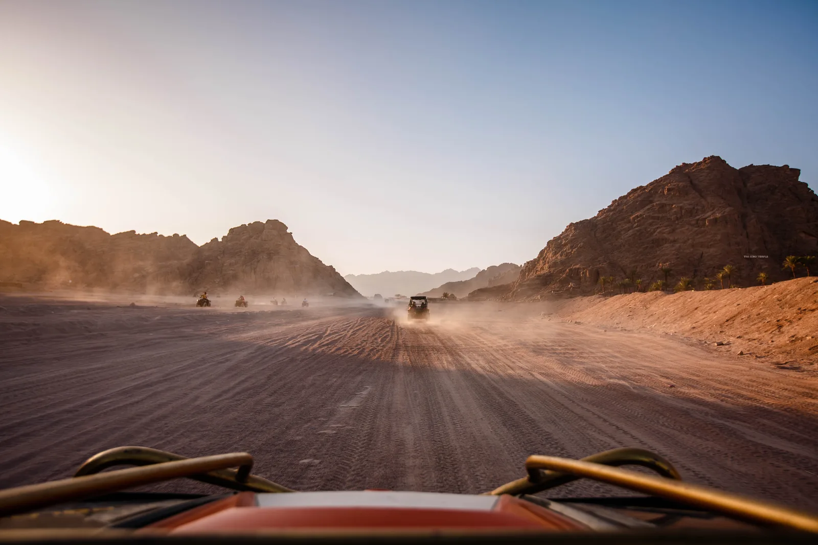 A buggy heading into a sunlit desert valley
